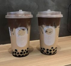 two coffee cups sitting on top of a wooden table