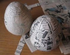 two newspaper balls sitting on top of a wooden table