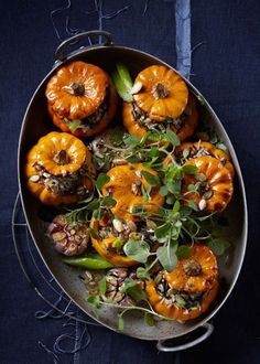 a pan filled with oranges and greens on top of a table