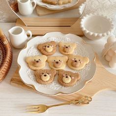 there are some cookies shaped like teddy bears on a plate with gold trimmings