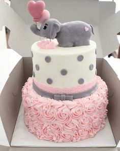 a pink and white cake with an elephant on top