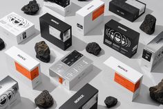 an assortment of different boxes and rocks on a white surface with black and orange accents