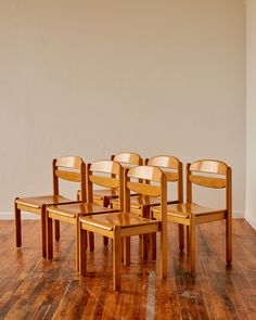 six wooden chairs sitting on top of a hard wood floor