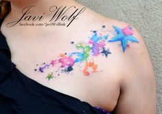 a woman's chest with colorful stars on it and watercolor paint splatters all over her