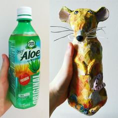 a hand holding an animal made out of aloe and a bottle of aloe