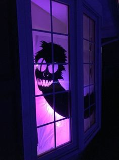 a window with an image of a person's face on it in the dark