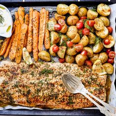 a pan filled with fish, potatoes and carrots