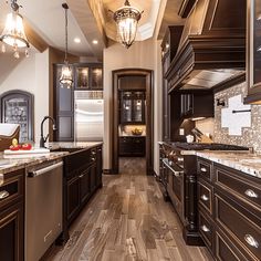 a large kitchen with wood floors and dark brown cabinets, along with marble counter tops