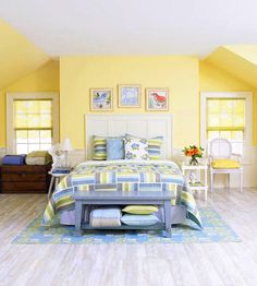 a bedroom with yellow walls and white furniture in the room, including a large bed