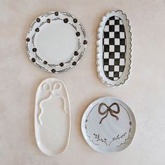 three plates with designs on them sitting next to each other in front of a white wall