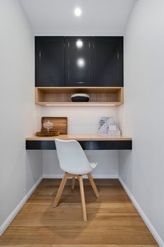 a white chair sitting in front of a desk with a shelf on top of it