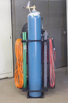 a large blue water tank sitting next to some orange and green hoses