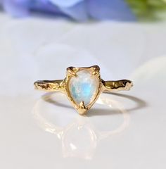 Show your special Love with our delicate Moonstone ring. Handcrafted in wax and cast in your choice of Solid Sterling Silver or Solid 14k Gold, our ring features a stunning Pear shape rainbow Moonstone - also the birthstone for June - and artfully set by prongs on an organic textured band, ensuring its uniqueness.  T H E ∙ S M A L L ∙  D E T A I L S * Pear shape rainbow Moonstone (6 x 8mm) * Solid 14k Gold textured band M A T E R I A L ∙ O P T I O N S * Sterling Silver * Solid 14k Gold You will receive a ring very similar to the one posted in this listing but it might differ slightly as all my rings are individually custom handcrafted for each buyer. No two settings are alike and this is what makes each of my rings unique!  S H O P ∙ M Y ∙ B R I D A L ∙ C O L L E C T I O N https://etsy.me/ Untreated Recycled Gold Jewelry As A Gift, Recycled Gold Untreated Jewelry As A Gift, Untreated Recycled Gold Jewelry Gift, Unique Yellow Gold Moonstone Ring For Anniversary, Promise Rings With Birthstone And Moonstone, 14k Gold Moonstone Gemstone Ring For Promise, Unique 14k Gold Moonstone Ring Gift, 14k Gold Moonstone Ring For Promise, Dainty Hand Forged Rings For Anniversary