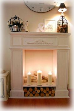 a white fireplace with candles and pictures on the mantle