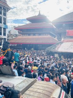 a large group of people standing in front of a building with an elephant statue on top