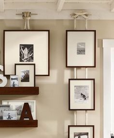 there are many frames on the wall with letters and pictures above them, along with other items