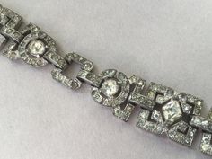 "Absolutely beautiful 1920's style \"Flapper\" bracelet. Studded with clear, sparkling, paste rhinestones on silver tone pot metal backing. This romantic stunner has a jeweled fold over clasp. I think this was made in the '20's or '30's. This particular Art Deco style was popular for many years. Larger stones are prong set. Very nice antique condition. Length: 7 1/2\" 5/8\" W (at widest) Attention: All items are listed to the best of our observation, but they are pre-owned and pre-loved (meaning Silver Platinum Bracelets For Evening, Art Deco Diamond Bracelet With Accents, Vintage Diamond Tennis Bracelet For Wedding, Evening Diamond Bracelets With Rhinestones, Art Deco Silver Diamond Bracelet, Art Deco Silver Diamond Bracelets, Art Deco Diamond Bracelet In Silver, Art Deco Rhinestone Jewelry For Formal Occasions, Silver Art Deco Diamond Bracelet