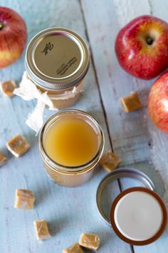 apples and peanut butter are on the table next to some caramels, honey