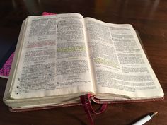 an open bible on top of a wooden table