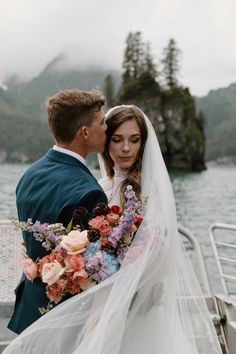 a bride and groom standing on a boat