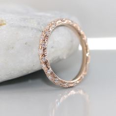 a close up view of a wedding ring on a rock with white stones in the background