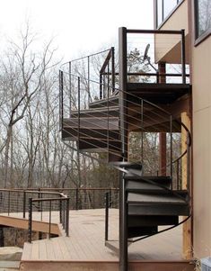 there is a spiral staircase going up the side of a building with trees in the background