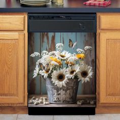 a pot full of flowers sitting on top of a kitchen counter