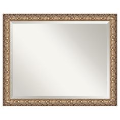 an ornate gold framed mirror on a white wall