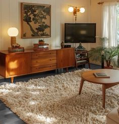 a living room filled with furniture and a flat screen tv on top of a wooden stand