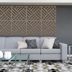 a living room with a gray couch and coffee table in front of a wooden paneled wall