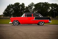 an old red and black car parked on the street