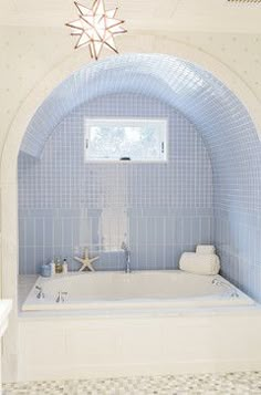 a white bath tub sitting under a window next to a starfish