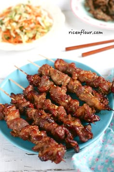 skewers of meat and vegetables on a blue plate