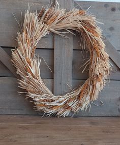 a close up of a wreath on a wooden wall with planks in the background