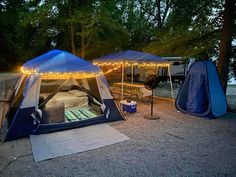 two tents are set up next to each other with lights strung from the tent roof