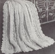 an old fashioned crocheted blanket on a bed