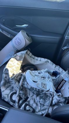 the inside of a car with sports equipment in its passenger seat, including an ice pack and water bottle