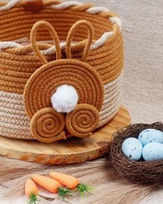 an easter basket with eggs and carrots next to it