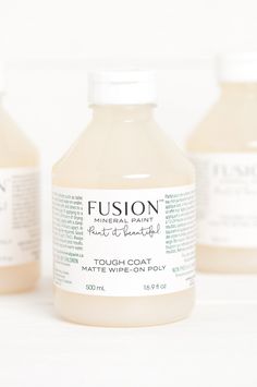 three bottles of liquid sitting next to each other on a white counter top, with one bottle labeled fuson