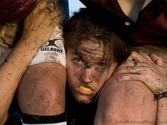 two people covered in mud and dirt with their hands on each other's shoulders