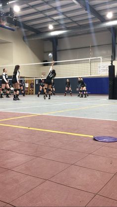 a group of people playing volleyball on a court