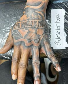 a hand with the words the world is yours written on it and an eagle tattoo