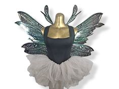 a mannequin dressed in white and green with wings on it's back