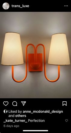 two lamps are on the wall next to each other, one is orange and the other is white