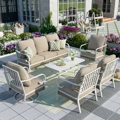 an outdoor patio with furniture and flowers in the background