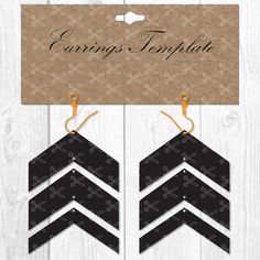 black and white chevroned paper earrings with gold hooks on the side, sitting next to a cardboard card