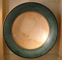 a green and black plate sitting on top of a wooden shelf