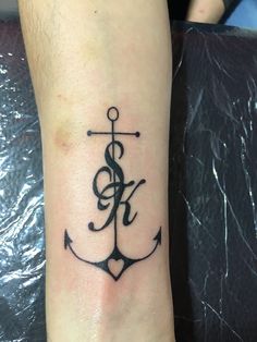 a small anchor tattoo on the wrist with music notes and treble clefs