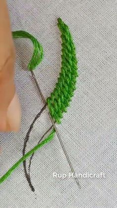 someone is working with green thread on a piece of fabric