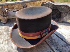 My "Top Gambler" hat in black. Thick wool felt  hand blocked and shaped by me. This one has two layers of grosgrain ribbon, chocolate first then old gold over it. Calf leather inner sweatband with a cotton liner. The crown height is 4 3/8" and the brim is 1 7/8".  Size is 7 1/8. My hats are all one of a kind. I make them all myself one at a time.  The hat you see in the pictures is the exact hat you will receive. Here is a video of me making this hat. https://youtu.be/SmLOH0knDnM All my hats are made from either wool, rabbit or beaver felts. I use all cotton for the thread, ribbon and brim bindings. I use reeded leather sweatbands for a very comfortable and durable fit.  Let me know if you have any questions. Thanks for looking. If you would like to order a hat in a different color or size Custom Fitted Brown Top Hat, Custom Brown Top Hat For Western-themed Events, Brown High Crown Fedora For Western-themed Events, Handmade Western Brown Top Hat, Handmade Brown Top Hat For Western-themed Events, Brown High Crown Top Hat For Rodeo, Festival Top Hat With Short Brim, Vintage Top Hat For Western-themed Events, Winter Top Hat For Western-themed Events